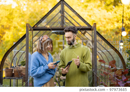 Stylish couple hang out in garden Stylish couple hang out in garden 97973685
