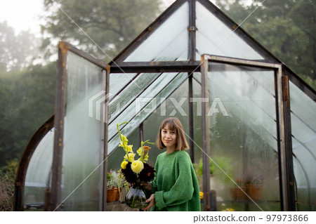 Woman with flowers in greenhouse 97973866