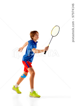 Portrait of teen boy in uniform playing badminton, training, posing with racket isolated over white background. Winner 97974146