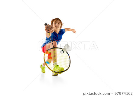 Portrait of teen boy in uniform playing badminton, hitting shuttlecock with racket isolated over white background. Goal 97974162