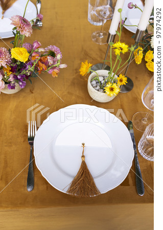hairs and a table for guests, decorated with candles, are served with cutlery and crockery 97974292