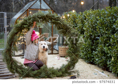 Woman with a dog in Christmas wreath at backyard Woman with a dog in Christmas wreath at backyard 97974831