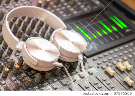 white headphone on audio mixing console. music background or recording concept 97975509