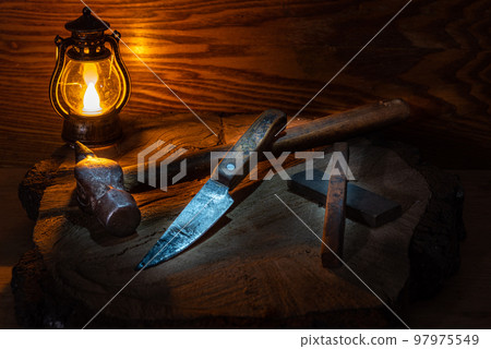 Vintage still life with old hand tools and a candle. Old hammer and knife. Still life with a candle. Vintage still life with old hand tools and a candle. Old hammer and knife. Still life with a candle. 97975549