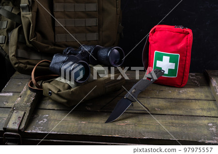 Angle top view on military composition. Army knife with olive handle and black blade. Binoculars for searching. Knife. Angle top view on military composition. Army knife with olive handle and black blade. Binoculars for searching. Knife. 97975557
