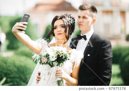 Young wedding couple taking a selfie of themselves 97975576
