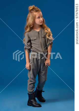 Little girl with a long curly hair in a fashionable clothes 97976913