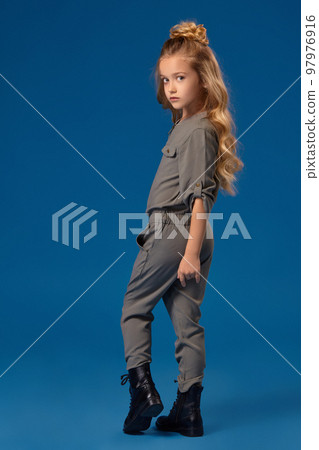 Little girl with a long curly hair in a fashionable clothes 97976916