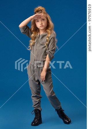 Little girl with a long curly hair in a fashionable clothes 97976919