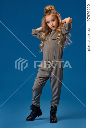 Little girl in a fashionable clothes on blue background 97976920