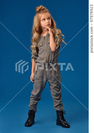 Little girl with a long curly hair in a fashionable clothes Little girl with a long curly hair in a fashionable clothes 97976923