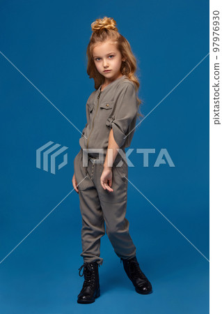 Little girl in a fashionable clothes on blue background Little girl in a fashionable clothes on blue background 97976930
