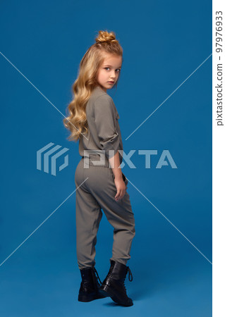 Little girl in a fashionable clothes on blue background 97976933