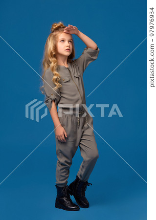 Little girl in a fashionable clothes on blue background Little girl in a fashionable clothes on blue background 97976934