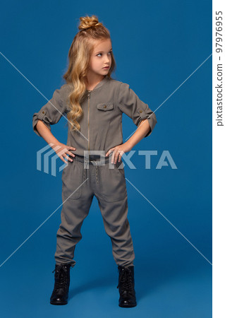 Little girl in a fashionable clothes on blue background Little girl in a fashionable clothes on blue background 97976955