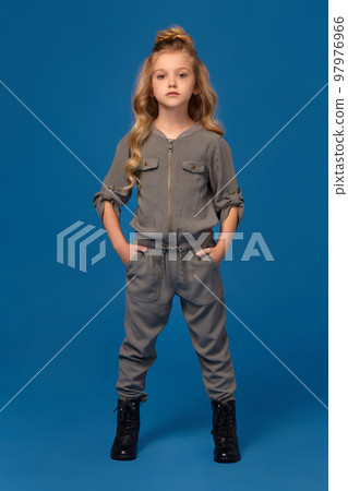 Little girl in a fashionable clothes on blue background Little girl in a fashionable clothes on blue background 97976966