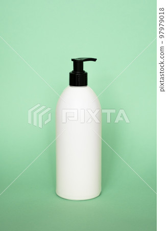 White plastic soap with black dispenser pump bottle on pastel green background. Skin care lotion, shampoo bottle, bath and body lotion. Bathroom accessories. 97979018