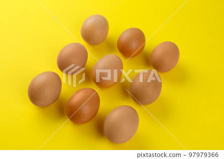 Raw chicken eggs on yellow background, above view 97979366