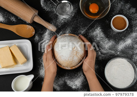 Woman with fresh dough at black table, top view. Baking pie Woman with fresh dough at black table, top view. Baking pie 97979378