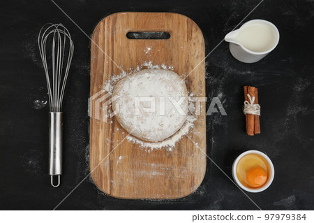 Flat lay composition with raw eggs and other ingredients on black background. Baking pie 97979384