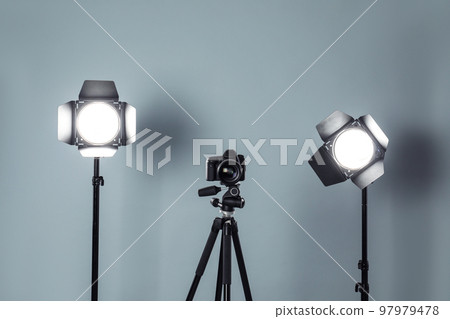 Professional video camera and lighting equipment on grey background Professional video camera and lighting equipment on grey background 97979478