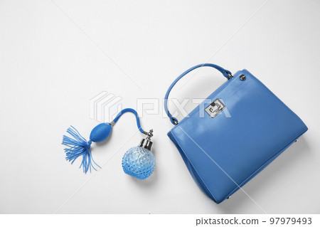 Stylish purse and perfume bottle on white background, top view. Classic blue - color of the Year 2020 Stylish purse and perfume bottle on white background, top view. Classic blue - color of the Year 2020 97979493
