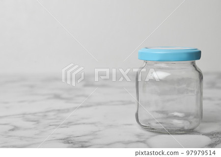 Empty glass jar on white marble table, space for text Empty glass jar on white marble table, space for text 97979514