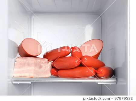 Delicious fresh sausages on shelf in refrigerator 97979558