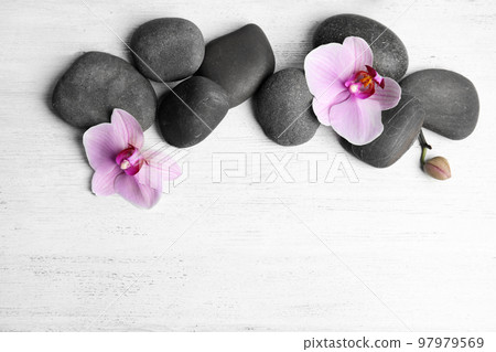 Stones with orchid flowers and space for text on white wooden background, flat lay. Zen lifestyle 97979569