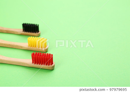 Natural bamboo toothbrushes on green background. Space for text Natural bamboo toothbrushes on green background. Space for text 97979695