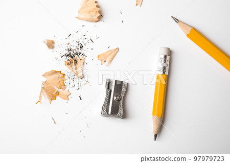 Graphite pencils, shavings and sharpener on white background, top view 97979723