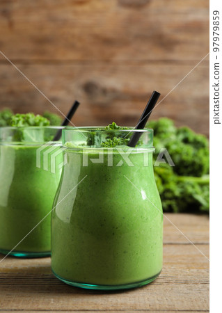 Tasty fresh kale smoothie on wooden table Tasty fresh kale smoothie on wooden table 97979859
