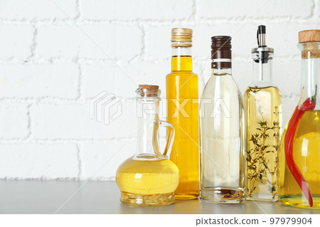 Different cooking oils on grey table. Space for text 97979904