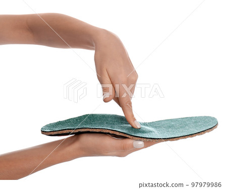 Woman showing orthopedic insole on white background, closeup Woman showing orthopedic insole on white background, closeup 97979986