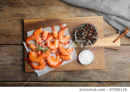 Delicious cooked shrimps with rosemary and spices on wooden table, flat lay Delicious cooked shrimps with rosemary and spices on wooden table, flat lay 97980126