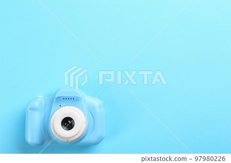 Toy camera on light blue background, top view. Space for text Toy camera on light blue background, top view. Space for text 97980226