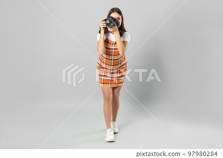 Professional photographer working on light grey background in studio 97980284