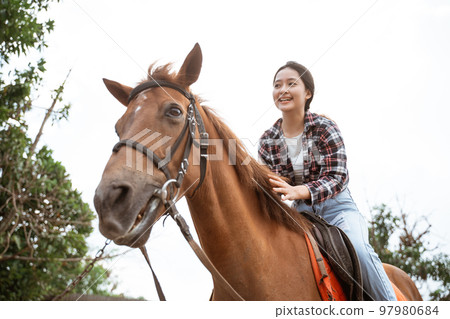 beautiful asian cowboy girl standing beside horse on outdoor background beautiful asian cowboy girl standing beside horse on outdoor background 97980684
