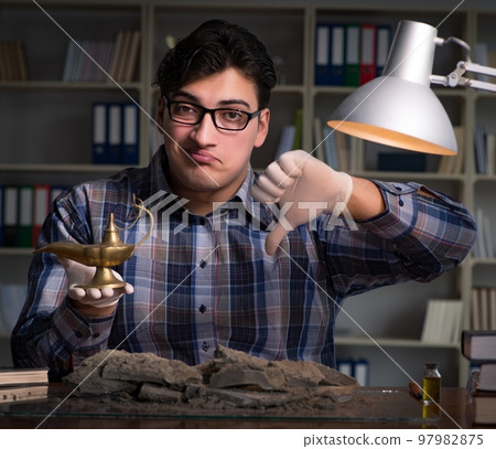 Archeologist working late night in office 97982875