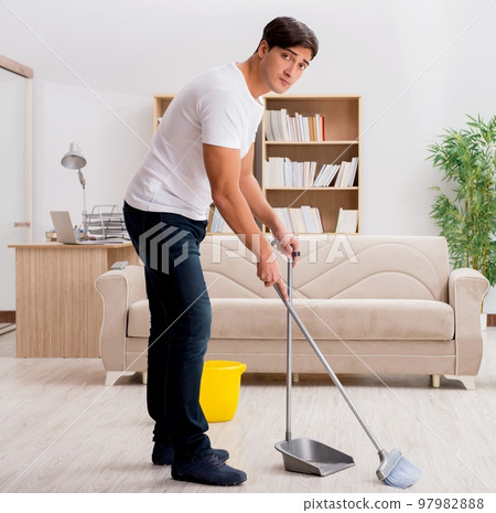Man cleaning home with broom 97982888