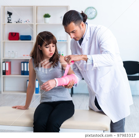 Young woman visiting male doctor traumatologist 97983317