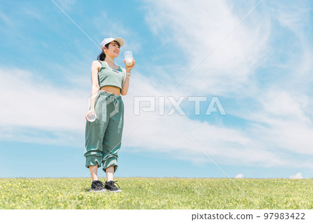 藍天下公園裡喝蛋白質、牛奶、豆漿的亞洲女性 97983422