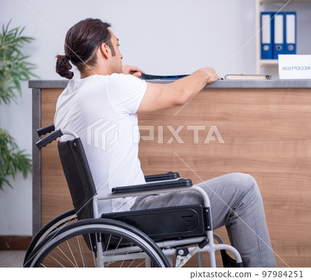 Young man at hospital reception desk 97984251