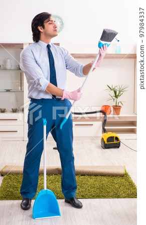 Young businessman cleaning the house Young businessman cleaning the house 97984337