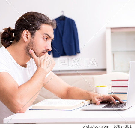 Young male student preparing for exams at home Young male student preparing for exams at home 97984391