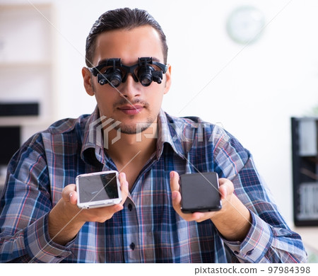 Young handsome technician repairing mobile phone 97984398