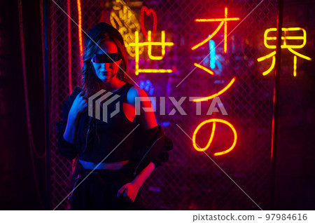 Caucasian woman in sunglasses posing in neon studio. 97984616