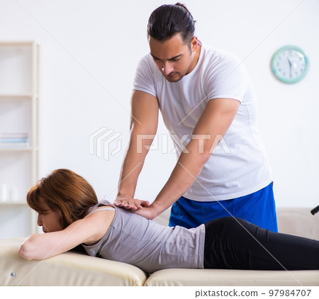 Young woman visiting male doctor physiotherapist 97984707