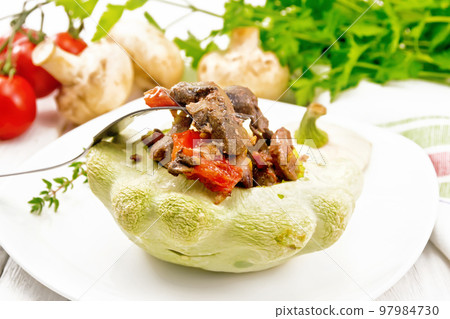 Patisson stuffed with liver and vegetables in plate on white board 97984730