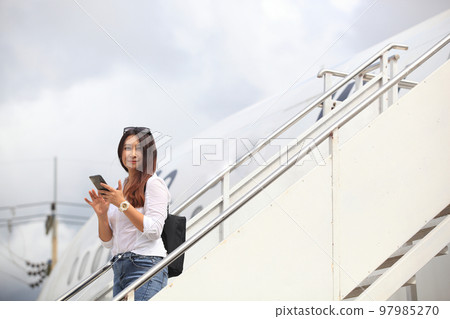 Traveling and Business concept,woman take photo when she walkimg  in to the plane 97985270